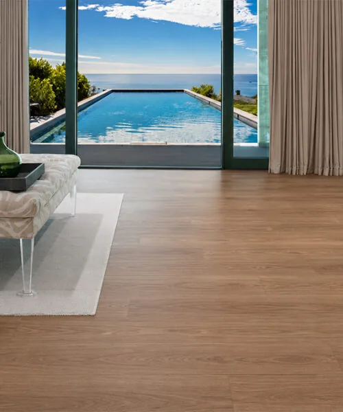 American Red Oak - 7/16" (11mm) - Swiss Design Cork Floating (FRed11) Durable wood-look Swiss cork flooring in a coastal living room with fireplace and ocean view
