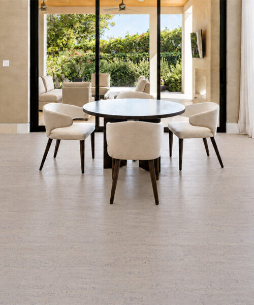 Bleached Birch 12mm cork floor planks show soft off-white grain beneath a garden-facing breakfast nook.