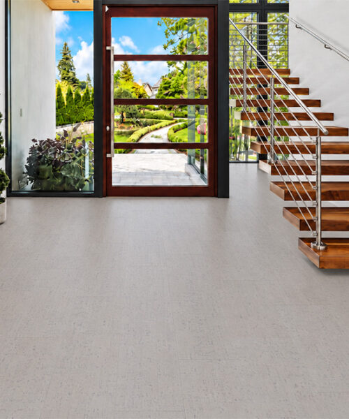Bleached Birch 12mm cork floor planks with pale linear texture brighten a wood-door entryway.