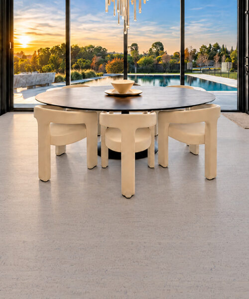 Bleached Birch 12mm floating cork flooring complements an oval dining table and expansive waterfront windows.