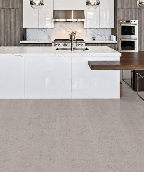 Bleached Birch pale gray cork floor planks feature natural linear grain in a modern white kitchen.