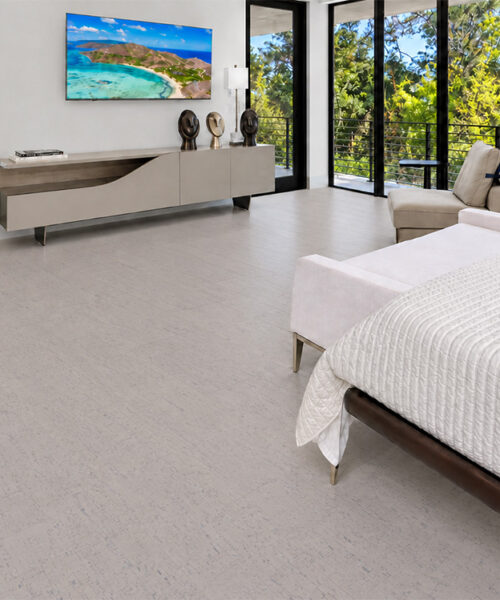 Bleached Birch 12mm off-white floating cork flooring extends across a bright bedroom with corner windows.