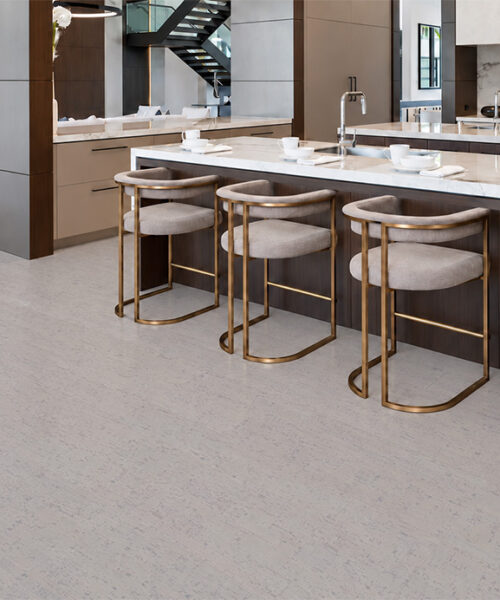 1. Bleached Birch natural cork flooring in pale gray tones surrounds a marble island with brass stools.