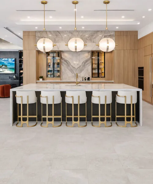 Neutral stone-look flooring enhancing a luxury kitchen with spacious island seating