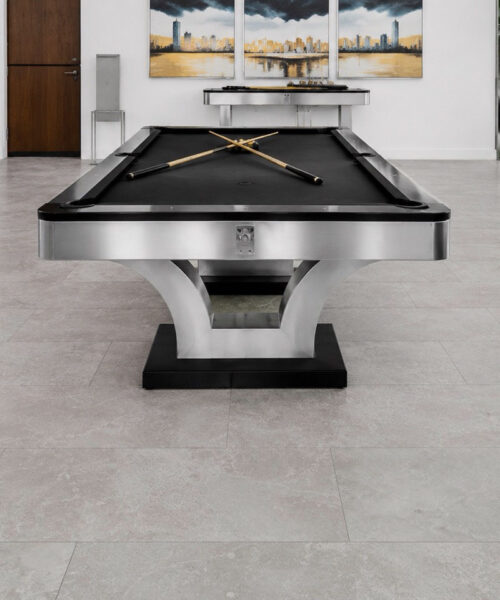 Bright Stone contemporary architectural flooring complements a modern billiards room with a sculptural pool table and city artwork.