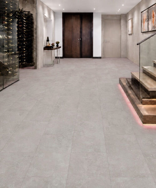 A glass wine cellar and floating staircase frame Bright Stone mineral-based flooring in a contemporary residential hallway.
