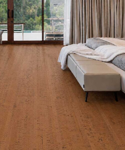 Cherry Line - 7/16" (11mm) - Swiss Real Cork Floating (FCHL11) Warm Cherry Line cork flooring with subtle linear grain surrounds a bed and lounge chair.