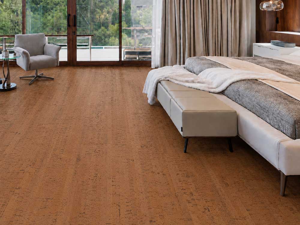 Cherry Line - 7/16" (11mm) - Swiss Real Cork Floating (FCHL11) Warm Cherry Line cork flooring with subtle linear grain surrounds a bed and lounge chair.