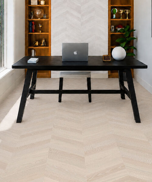 Clara Chevron - 7/16″ (11mm) – Swiss Design Cork Floating (FCla11) Clara Chevron cork flooring for an office features pale gray chevrons beneath a black desk and shelving.