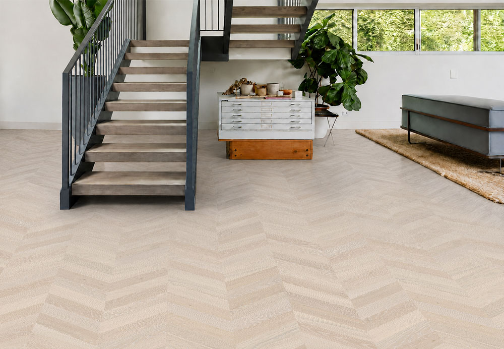 Clara Chevron - 7/16″ (11mm) – Swiss Design Cork Floating (FCla11) Clara Chevron natural cork flooring covers a bright stairway lounge with modern furniture and tropical plants.
