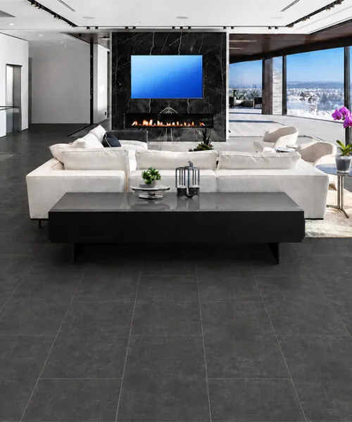 Dark gray Concrete Alloy TechSlate flooring in an open-plan luxury home with marble walls.
