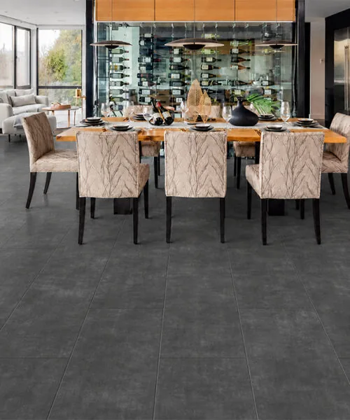 Concrete Alloy gray TechSlate flooring in a modern kitchen and dining room with a marble island.