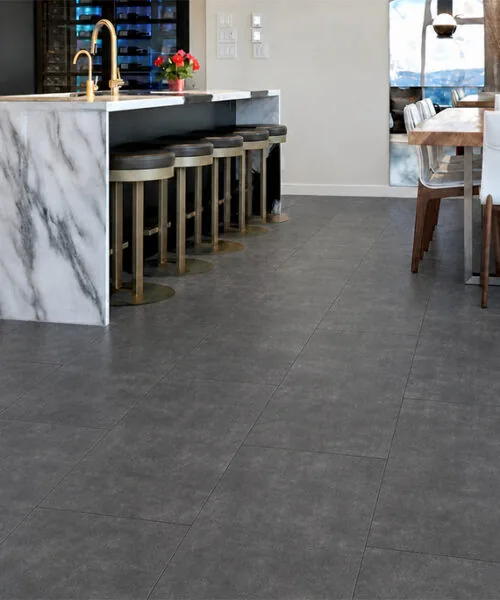Dark gray Concrete Alloy TechSlate flooring in an indoor-outdoor living space overlooking a mountain patio.