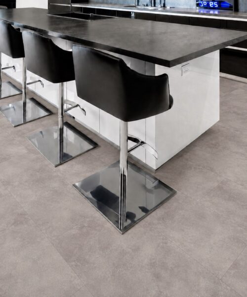 Copperstone Gray - 3/8" (9.5mm) - Forna Natural Composite Flooring with Waterproof Hydrowood Core (NCopG9.5) Copperstone Gray waterproof floating flooring adds a refined concrete-look finish to a modern kitchen with island seating.