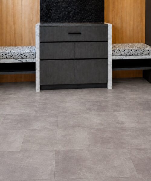 Copperstone Gray - 3/8" (9.5mm) - Forna Natural Composite Flooring with Waterproof Hydrowood Core (NCopG9.5) Copperstone Gray cork-backed flooring features subtle gray variation in a contemporary foyer with benches and dark accent walls.