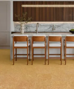 High-end kitchen design showcasing a marble island, wooden cabinetry, and natural Desert Arable cork flooring in a warm yellow-gold tone.