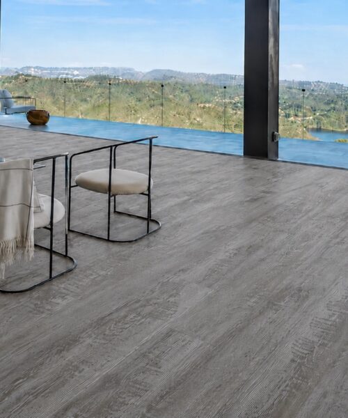 Earthy Pine natural composite flooring features cool gray pine grain in a contemporary living room with panoramic windows.