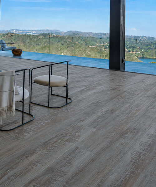 Earthy Pine natural composite flooring features cool gray pine grain in a contemporary living room with panoramic windows.