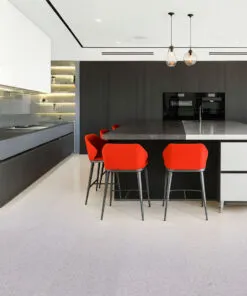 Grano - 25/64" (10mm) - Cork Floating (FGra10) Contemporary kitchen interior featuring natural Grano cork floors, red counter chairs, and matte black cabinetry for a stylish modern contrast.