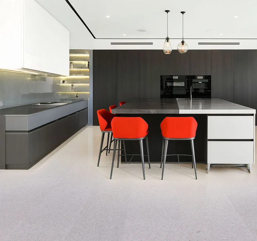 Contemporary kitchen interior featuring natural Grano cork floors, red counter chairs, and matte black cabinetry for a stylish modern contrast.