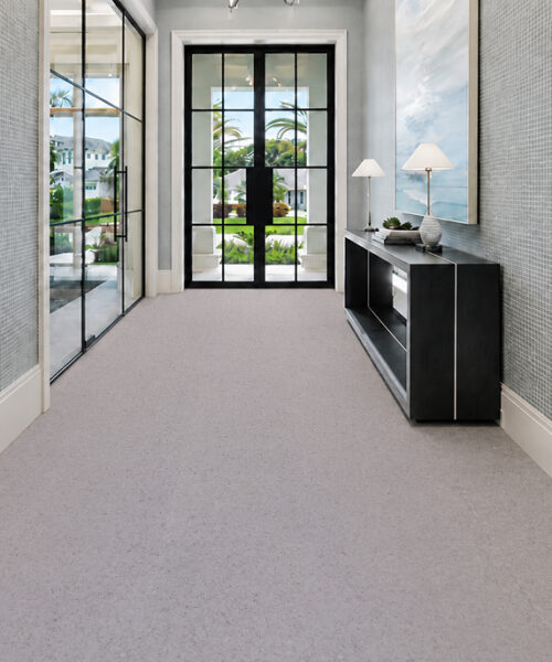 Grano - 25/64" (10mm) - Cork Floating (FGra10) Grano 10mm floating cork flooring with fine speckles extends through an entryway with a black console.