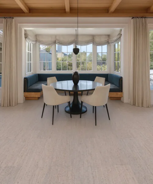 sunlit breakfast nook with soft curtains, round table, and stylish gray bamboo cork flooring