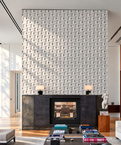 Decorative white 3D cork wall tiles with a basket weave design create a textured bedroom accent wall behind a cozy upholstered bed.