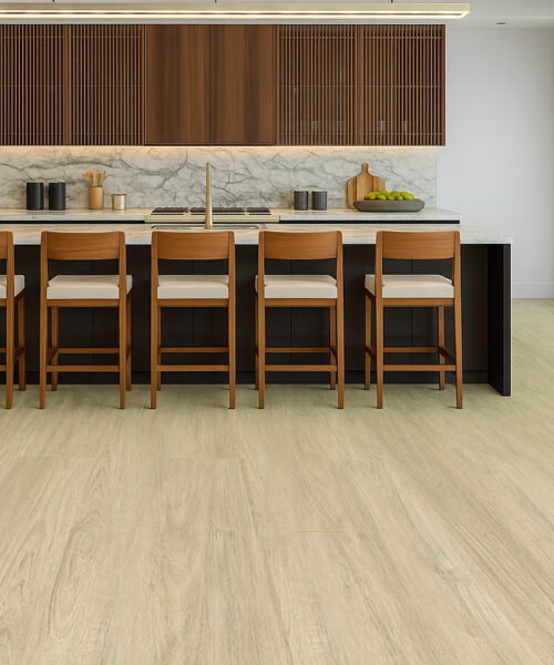 Elegant kitchen with Hamilton Swiss Cork floating flooring in a light oak finish, complemented by a marble island, wood cabinetry, and matching bar stools in a bright open-concept layout