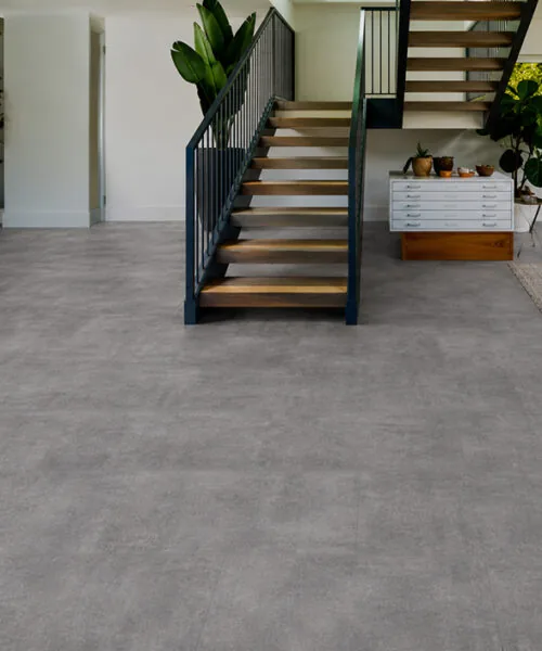 Industrial Grey Forna Natural Composite flooring in an open plan living and dining room with staircase