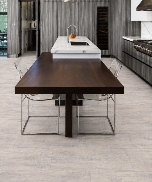 Ivory Concrete - 3/8" (9.5mm) - Forna Natural Composite Flooring with Waterproof Hydrowood Core (NICon9.5) Ivory Concrete Forna Natural Composite Flooring displays soft gray concrete texture throughout an open-plan kitchen and dining room.