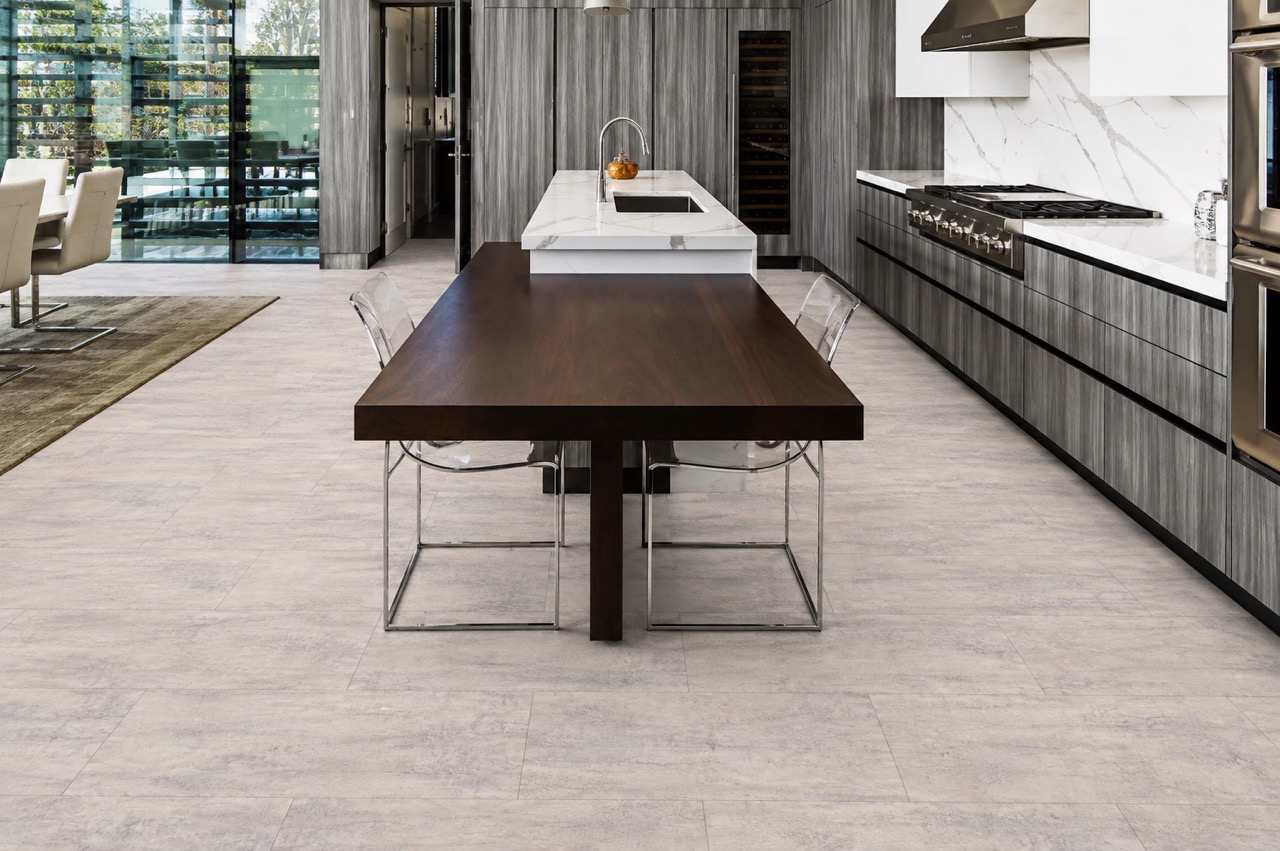 Ivory Concrete - 3/8" (9.5mm) - Forna Natural Composite Flooring with Waterproof Hydrowood Core (NICon9.5) Ivory Concrete Forna Natural Composite Flooring displays soft gray concrete texture throughout an open-plan kitchen and dining room.