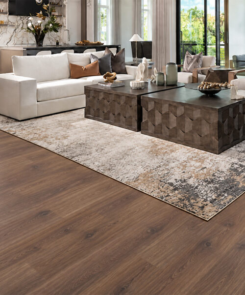 Sustainable Latte wood-look cork flooring creates a warm, comfortable home office with a large wood desk, built-in shelving, and garden windows.
