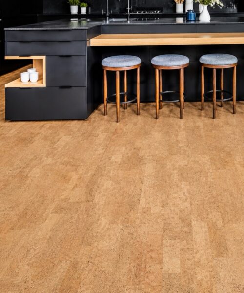 Contemporary black kitchen with a spacious island, wood accents, and warm Leather Natural cork floating flooring.