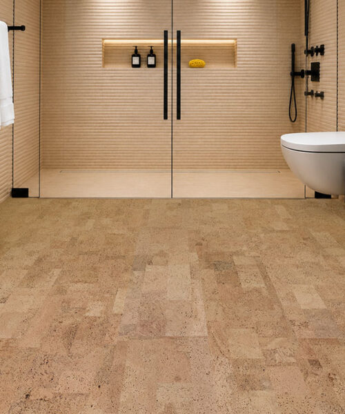 Spa-inspired bathroom featuring Leather Natural 6mm glue-down cork tile flooring, a walk-in glass shower, matte black fixtures, and a warm, comfortable natural cork floor sealed for bathroom use.