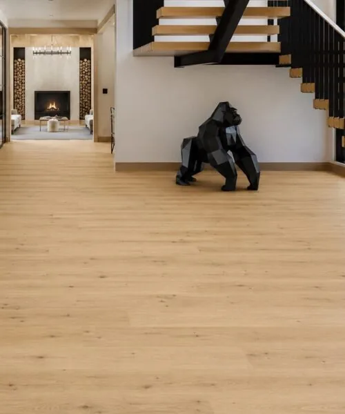 Light oak Long Beach Swiss Design cork floating flooring installed in a modern entryway with floating staircase, black steel accents, and open-concept luxury interior.