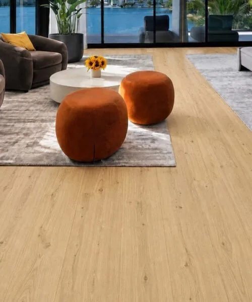 Bright waterfront master bedroom featuring Long Beach Swiss Design cork floating flooring with realistic light oak wood appearance and floor-to-ceiling windows.