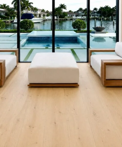 Long Beach Swiss Design cork floating flooring creates a bright, elegant foundation for a luxury living room overlooking a modern pool and waterfront landscape.