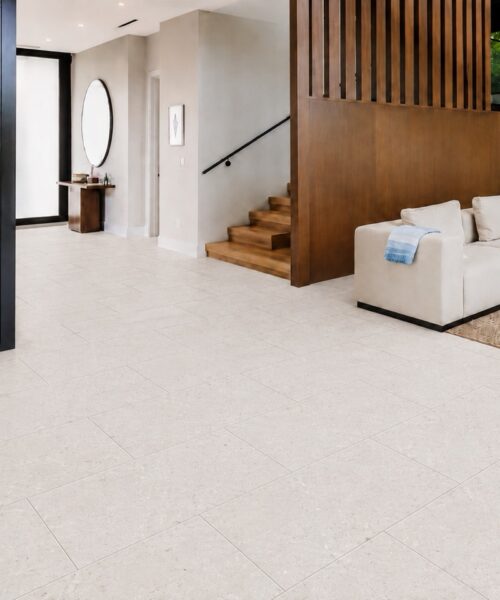 Matera Blend -19/64" (7.5mm) - Swiss Techslate (MMatBd7.5) Light limestone Matera Blend click-lock flooring spans a contemporary entryway and living room in rectangular stone-look planks beside a wine display.
