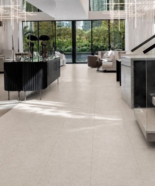 Matera Blend slate-look flooring in light limestone runs through a living area with wine display, lounge seating, and stairs.