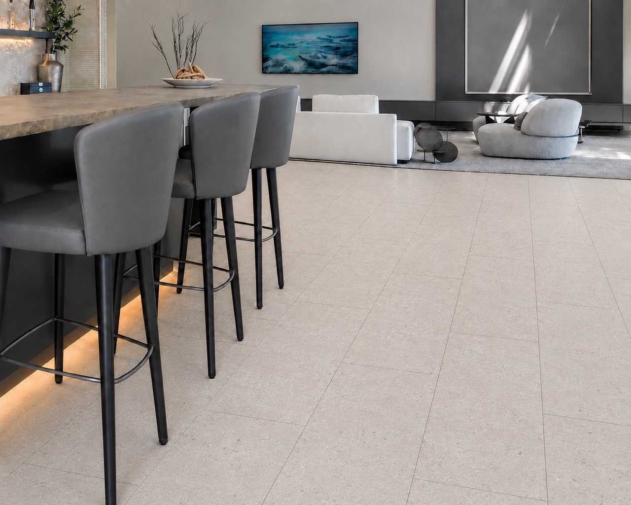 Matera Blend -19/64" (7.5mm) - Swiss Techslate (MMatBd7.5) Light limestone Matera Blend stone-look flooring extends across a kitchen and living area beneath a wood island with bar stools.