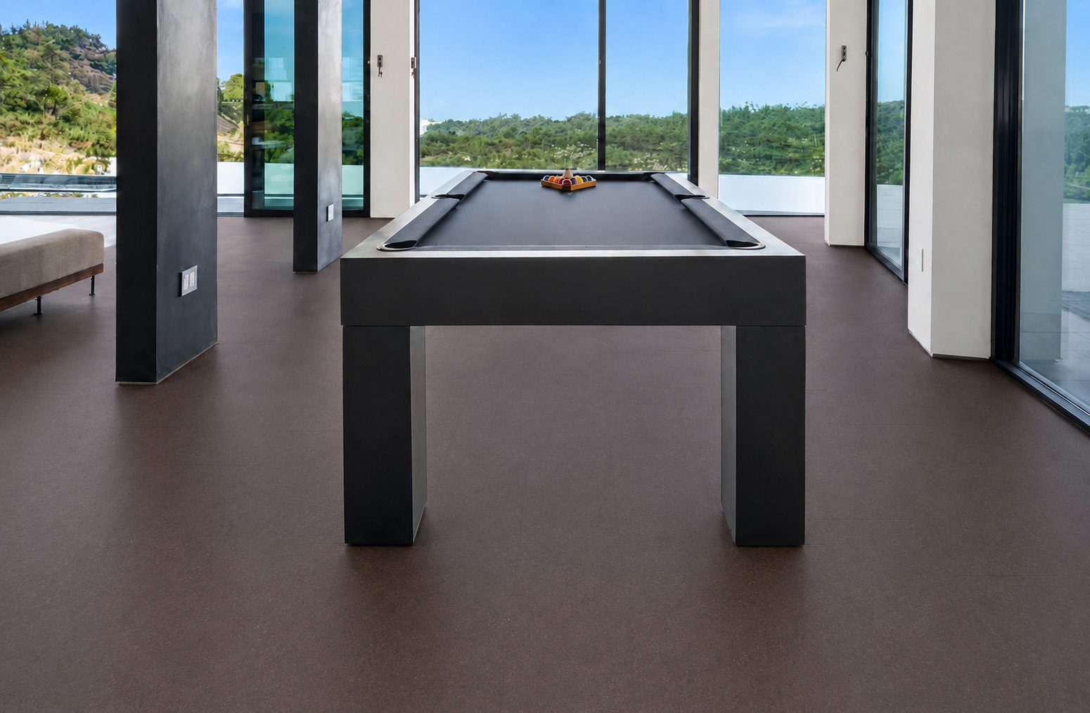 Night - 7/16" (11mm) - Swiss Real Cork Floating (FNig11) Night black floating cork flooring surrounds a pool table in a glass-walled modern recreation room.
