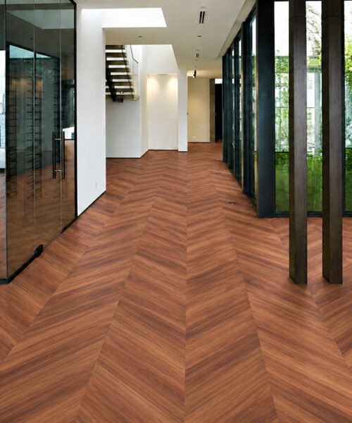 Walnut Noble Chevron floating cork flooring runs through a glass-walled foyer with modern architectural details.