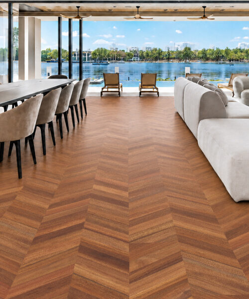 Noble Chevron comfortable cork flooring spans an open waterfront room with dining furniture and curved sofas.