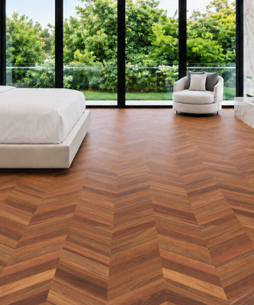 Noble Chevron wood-look cork flooring adds a warm geometric pattern to a bedroom with marble feature walls.