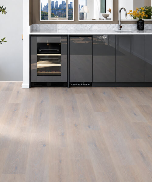 Nordic Oak natural composite click-lock flooring pairs pale oak grain with glossy black home bar cabinetry.