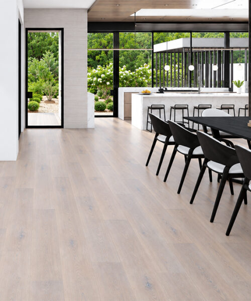 Nordic Oak waterproof Natural Composite Flooring brings light oak planks to a garden-facing kitchen and black dining table.