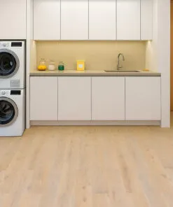 Nordic Oak - 3/8" (9.5mm) - Swiss Real Linoleum Hydrowood Core Waterproof Floating Flooring (NNorO9.5) Bright laundry room with Nordic Oak Swiss Linoleum Flooring, showing light oak planks, white cabinetry, stacked washers and dryers, and a clean minimalist design.