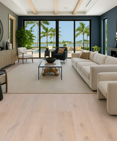 Nordic Oak - 3/8" (9.5mm) - Swiss Real Linoleum Hydrowood Core Waterproof Floating Flooring (NNorO9.5) Contemporary living room featuring Nordic Oak Swiss Real Linoleum Flooring in soft beige-oak tones, complemented by modern neutral furniture and a bright coastal view.