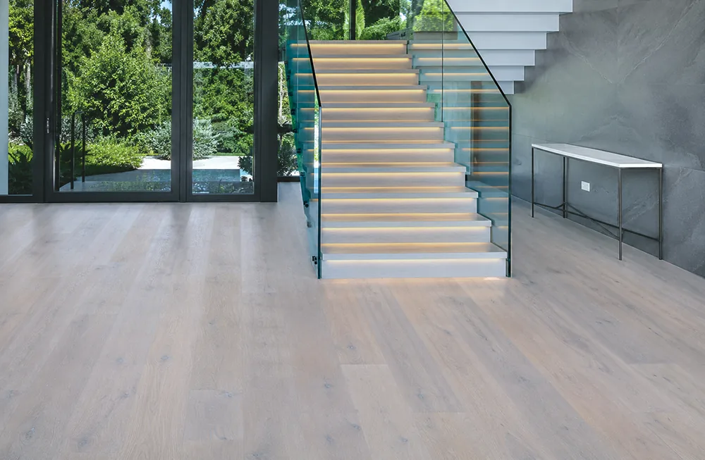 Nordic Oak - 3/8" (9.5mm) - Forna Natural Composite Flooring with Waterproof Hydrowood Core (NNorO9.5) Light Scandinavian oak flooring installed in a spacious home foyer beside a contemporary staircase