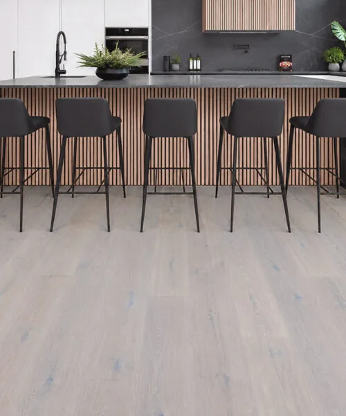 Nordic Oak - 3/8" (9.5mm) - Forna Natural Composite Flooring with Waterproof Hydrowood Core (NNorO9.5) Pale oak look floating flooring in a modern kitchen with marble countertops and white bar stools